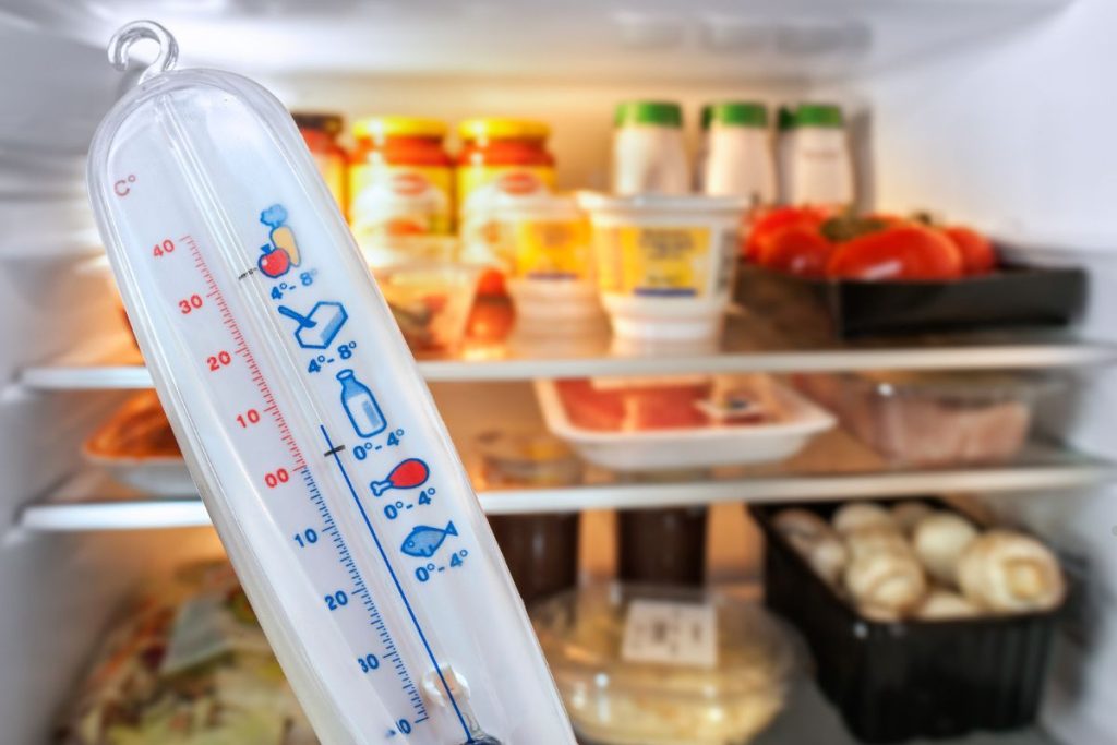  A thermometer placed inside an open refrigerator, displaying the current temperature for monitoring food safety.