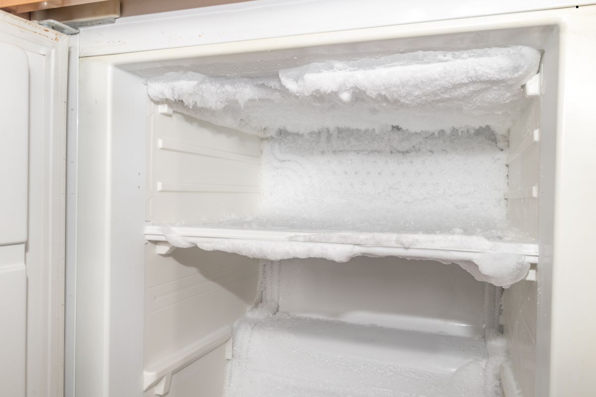 An open refrigerator displaying ice accumulation on the shelves, indicating potential issues with water quality