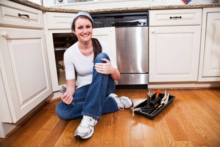 A woman on the floor, engaged with an assortment of tools, demonstrating her craftsmanship.