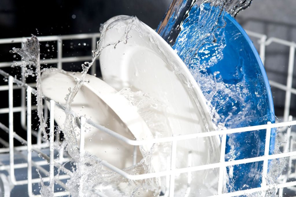 A dishwasher with water flowing over it, symbolizing appliance repair service in action.